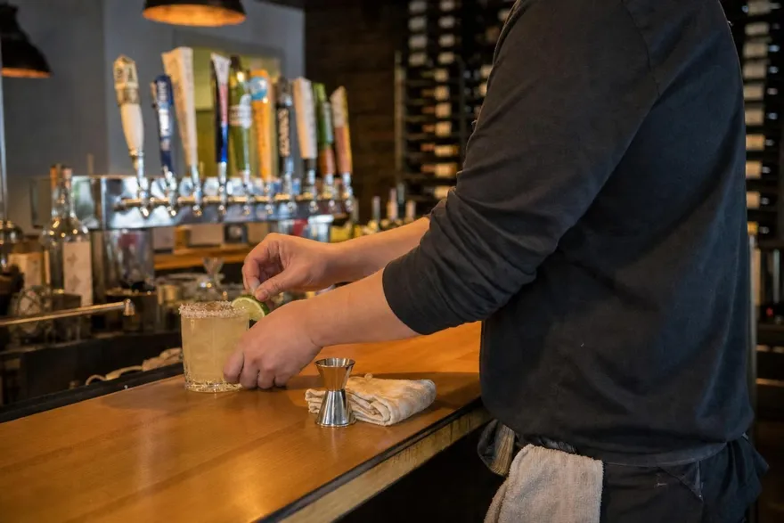 A bartender finishing a house margarita at the 42 Fusion bar
